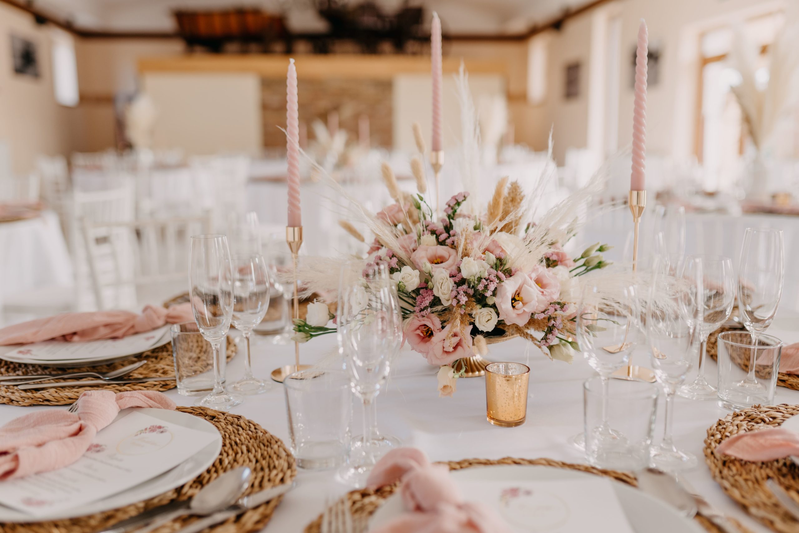 Priestor šúrovce s prichystanou svadobnou dekoráciou na stole. Kveta, dekorácie a stolovanie v jemných rúžových tónoch.